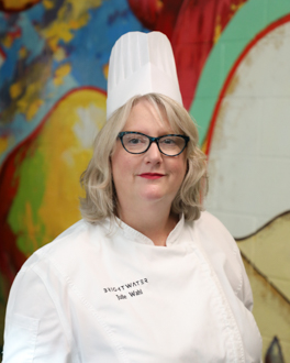 Woman wearing chef coat and hat