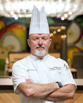 Man wearing chef coat and hat