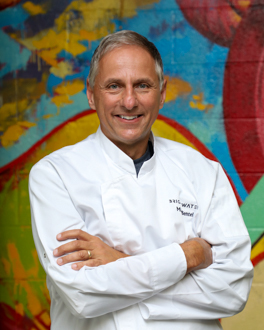 Man in white chef coat smiling